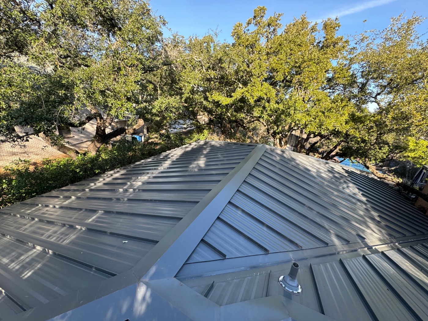 Charcoal standing seam metal roof at golden hour on a Central Texas home
