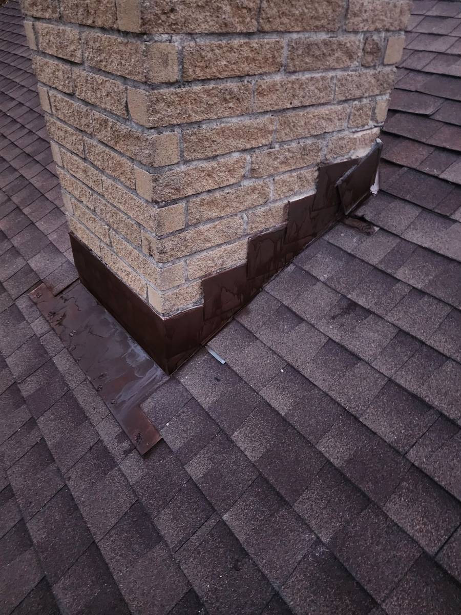 Hand-built galvanized chimney cricket and step flashing on an Austin roof · the detail work most crews subcontract out
