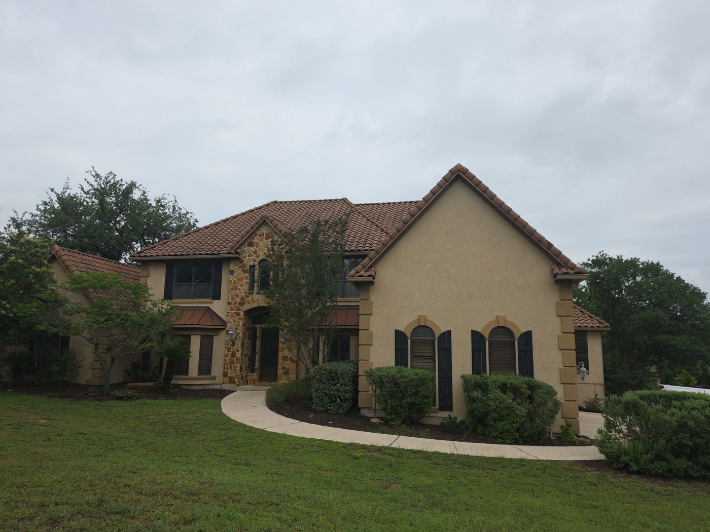 Finished clay tile roof on a stone Hill Country home, a system built to last decades