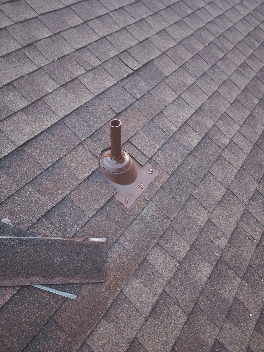 Finished pipe boot installation on the same Mr. Vasquez roof with a new lead-base flashing plate set under the shingle weave and a two-part urethane bead at the collar.