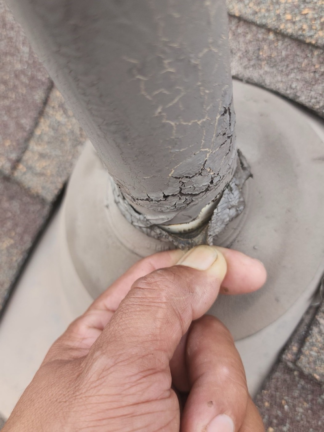 Close-up of a cracked Oatey neoprene pipe boot on the Mr. Vasquez El Rey Blvd roof with UV failure and split rubber collar, the most common single cause of ceiling stains around bathroom vents.